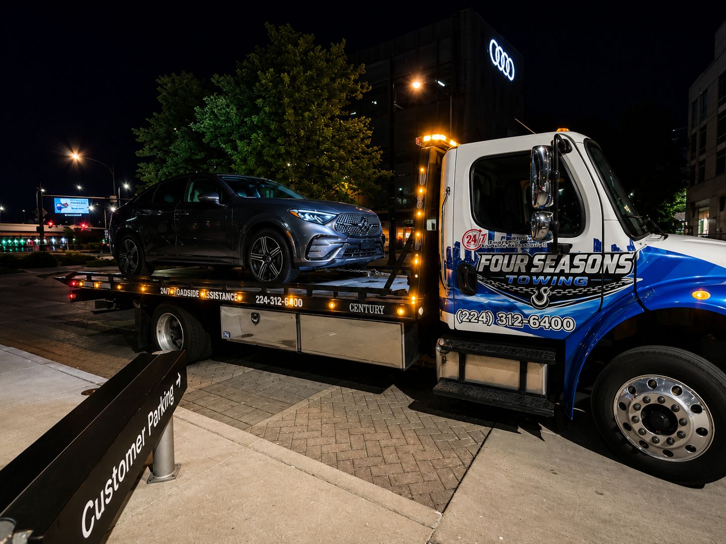 Four Seasons Towing flatbed loading an SUV at night in Chicago